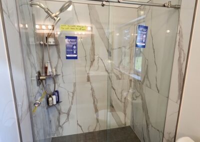 New shower with brushed nickel hardware, and sliding glass door